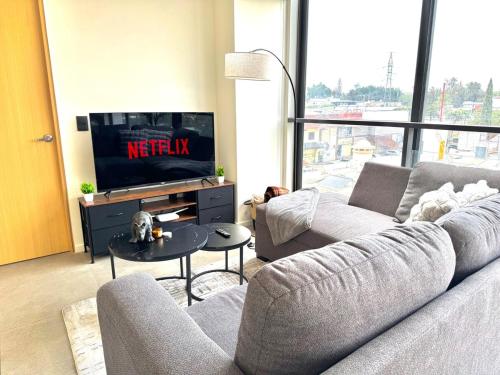 a living room with a couch and a tv at Beautiful apartment near Andares in Guadalajara