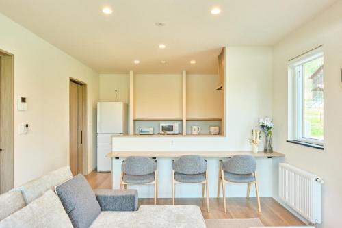 a living room with a couch and a kitchen at Shikauchi Furano in Nakafurano