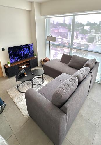 a living room with a couch and a tv at Beautiful apartment near Andares in Guadalajara