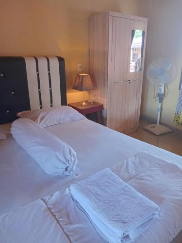 a white bed with two towels on top of it at marbun in Tuk Tuk