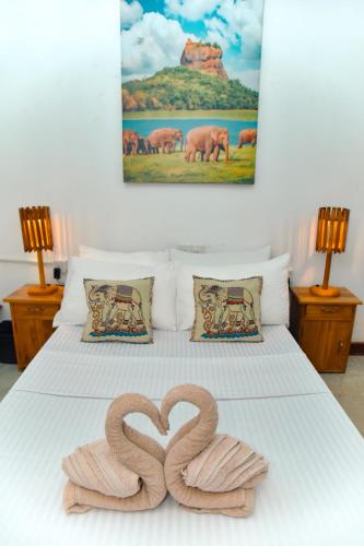 a bed with two pretzels in the shape of a heart at Dhona's Villa in Sigiriya