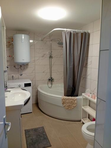 ein Badezimmer mit Badewanne, Toilette und Waschbecken in der Unterkunft Palanka in Sisak