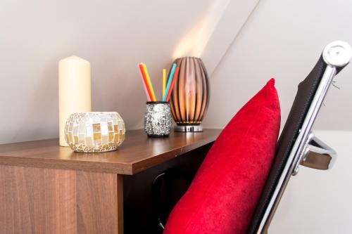 a bedroom with a red couch and a wooden table at Trivelles Mayfair,stockport in Manchester