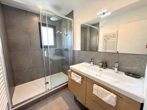 a bathroom with a shower and a sink and a mirror at Appartement spacieux, moderne, vue mer proche plage et centre-ville in Bastia