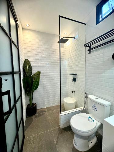 a bathroom with a toilet and a plant in it at Your Brothers House Tribal Village in Legazpi