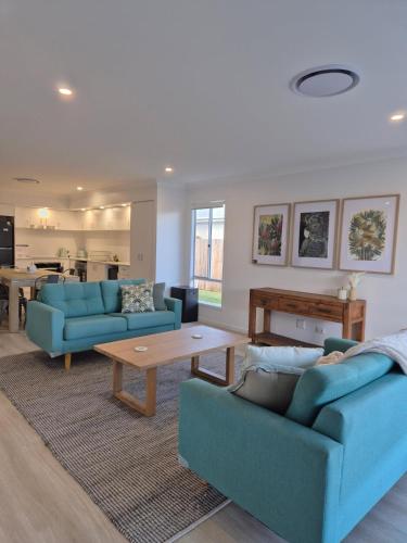 a living room with two blue couches and a table at Latsky Luxe Retreat in Toowoomba Airport
