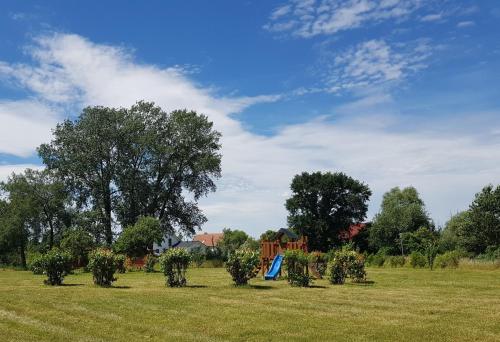 a field with trees and a blue kite in the grass at Ferienwohnung Mohnblume in Gerswalde