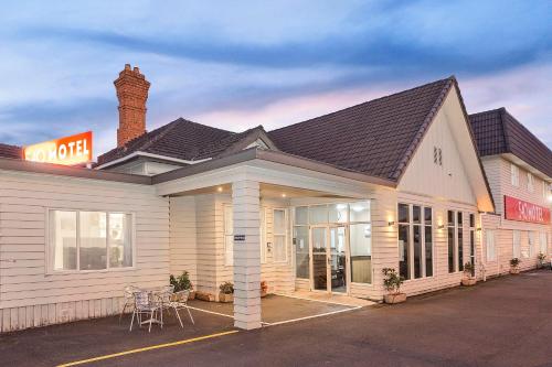 a building with a restaurant with tables and chairs at 540 on Great South Motel in Auckland