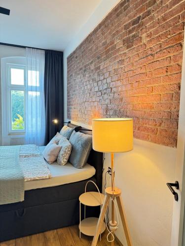 a bedroom with a bed and a brick wall at FOUR ROOMS Carlsbad Authentic in Karlovy Vary