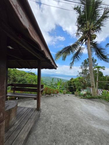 a house with a palm tree and a bench at Simoy Staycation Tagaytay in Tagaytay
