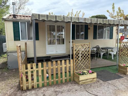 a small house with a wooden fence in front of it at Mobilehome P-Dante in Lido di Dante
