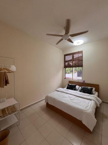 a bedroom with a bed with a ceiling fan at DQuatro Homestay in Kampong Jelatang