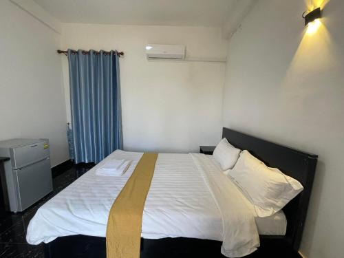 una camera da letto con un letto con lenzuola e cuscini bianchi di Romnea Moon Resort a Krong Saen Monourom