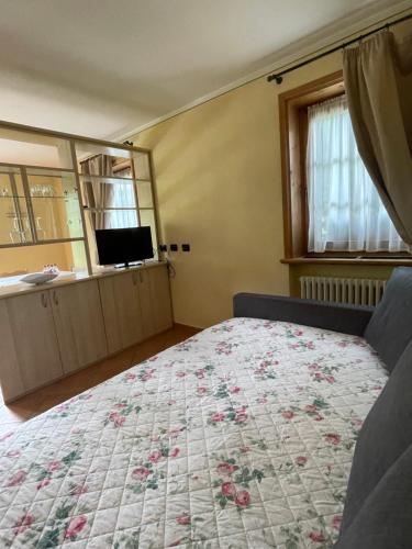 1 dormitorio con 1 cama con edredón de flores en Baita Brozol, en Livigno