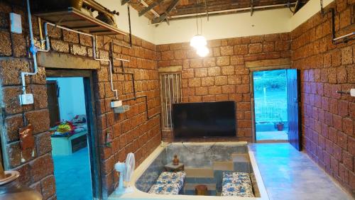 a room with a bath tub in a brick wall at Vyugen Villa #01 in Kāraikkudi