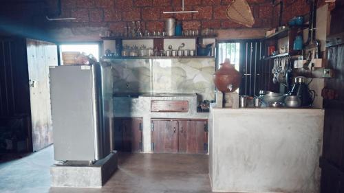 a kitchen with a refrigerator and a counter in it at Vyugen Villa #01 in Kāraikkudi