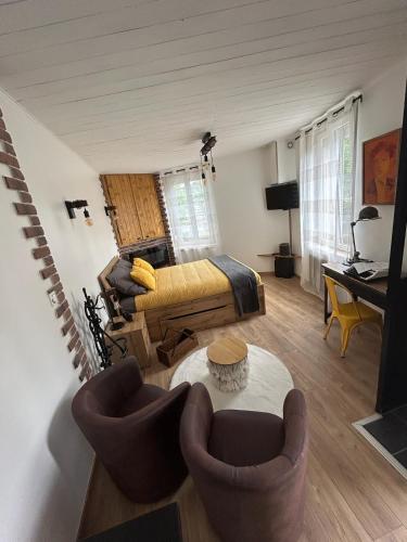 a living room with a couch and a table at Le Refuge de la Gravière in Charleville-Mézières