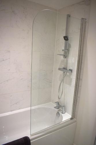 a shower in a bathroom with a bath tub at Tolson Court House in Fazeley
