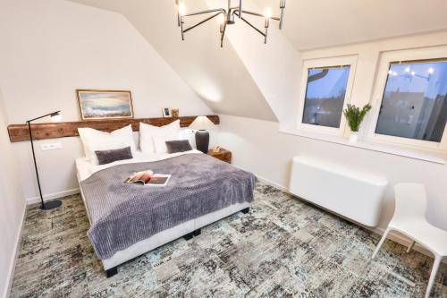 a bedroom with a bed and two windows at Neptun Badacsony in Badacsonytomaj