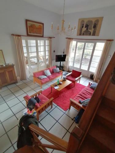 - une vue aérienne sur le salon doté d'un canapé rouge dans l'établissement Maison avec jardin face au lac et plage, à La Celle-sous-Gouzon