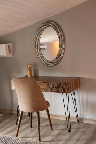 a dressing table with a mirror and a chair at Vot villas in Ormos Panagias