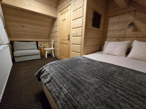 a bedroom with a bed and a chair in a room at Chocholowska Zohylina pokoje in Chochołów