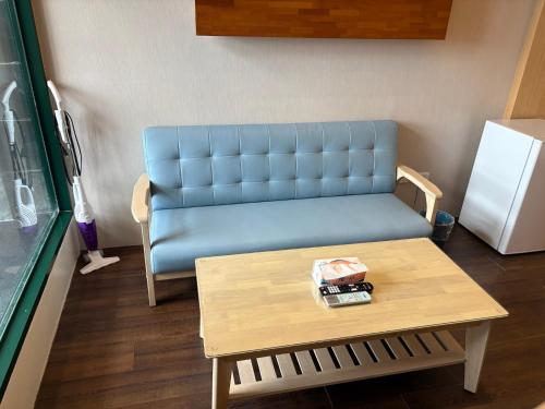 a living room with a blue couch and a table at 石焦溫泉民宿 in Jiaoxi