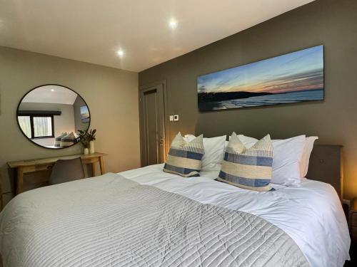 a bedroom with a large white bed and a mirror at Uno Moor Side - 4 Bed, 2 Bath, Garden, sleeps 8 - Parking in Carbis Bay
