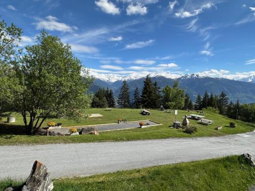 a road in a field with mountains in the background at Alpine Pearl - Panoramic Mountain Views - Aminona in Aminona