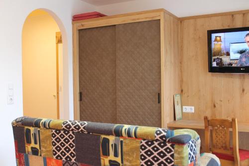 a living room with a couch and a flat screen tv at Hotel Sonne in Niederau