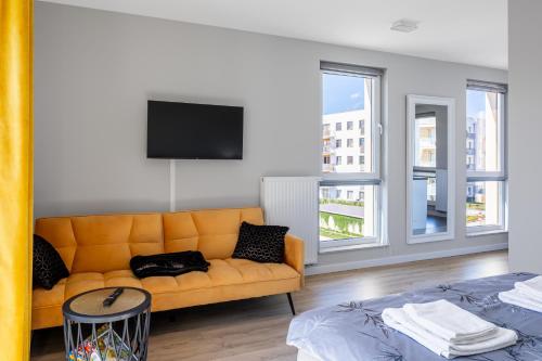 a living room with a couch and a tv at Apartament przy Błoniach in Rumia