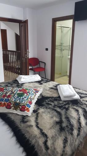 a bedroom with a bed with a black and white comforter at Popasul Călătorului in Moisei