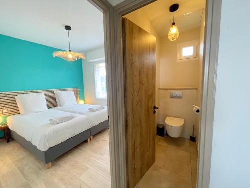 une chambre avec un lit et une porte donnant sur une salle de bain dans l'établissement PGH N44 - Grand Duplex Vue Mer, 50 m de la plage, à La Grande Motte