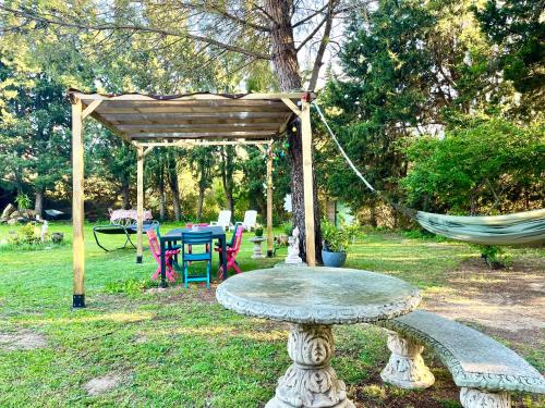 a hammock and a table in a garden at Villa 110m2, 7 pers, Jacuzzi , 3 chambres, terrain clos et arboré 2500m2 in Trèbes