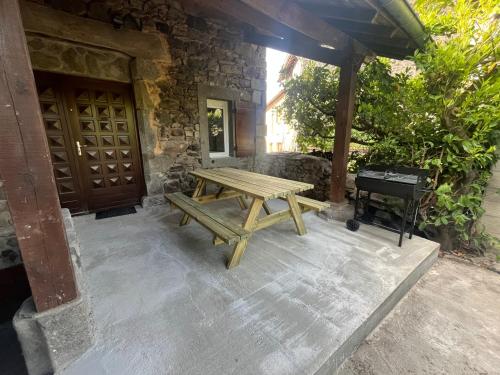 a picnic table in front of a building with a grill at Gite le Patou Retournac in Retournac