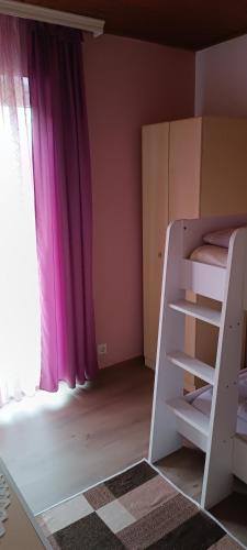 a bedroom with a bunk bed with pink curtains at Apartmenthaus Kestel Gasthof in Kirchbach