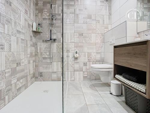 a bathroom with a toilet and a glass shower at Au murmure de l eau in Ebersheim