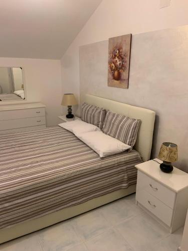 a small bedroom with a bed and a mirror at La Pigna in Marina di Sorso