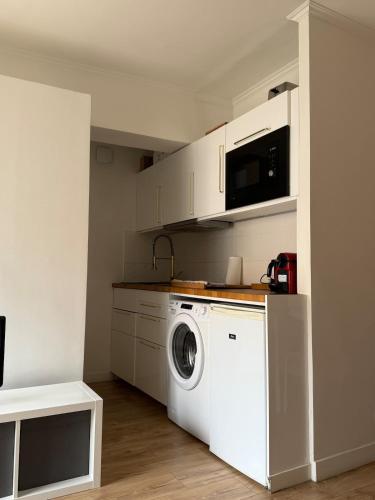 une cuisine avec un lave-linge et un micro-ondes dans l'établissement Seaside Retreat, à Nice
