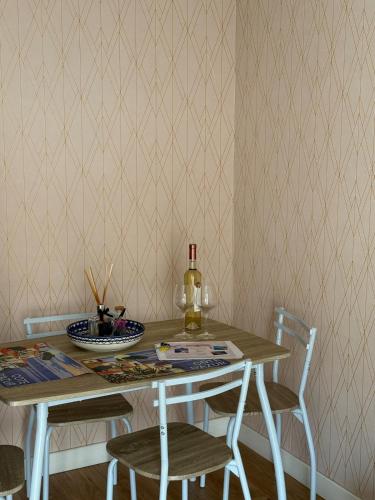- une table à manger avec une bouteille de vin et 2 chaises dans l'établissement Seaside Retreat, à Nice