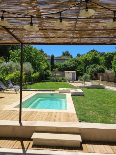 - une piscine dans une cour avec une pergola dans l'établissement Gîte Lou Galoubet, à Saint-Étienne-du-Grès