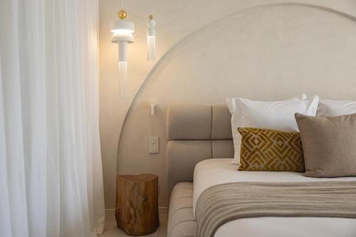 a bedroom with a bed and a table with pillows at Hôtel Cala di Greco in Bonifacio