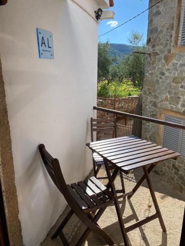 a wooden table and a chair on a balcony at Casa Museu da Avó Gena in Mazouco