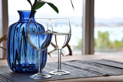 two wine glasses and a vase on a table at 青の家 in Kouri-shima