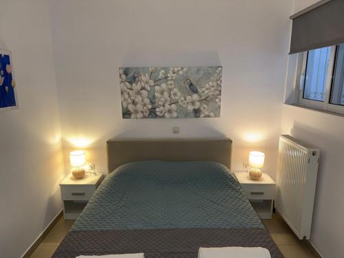 a bedroom with a bed with two night stands and two lamps at Sea view apartment in Paralion astros
