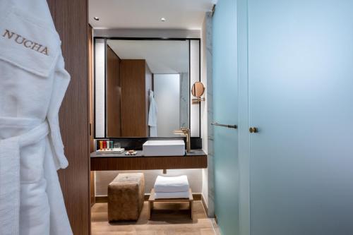 une salle de bain avec un lavabo et un miroir dans l'établissement Hotel Nucha-Fattal Colors, à Jérusalem