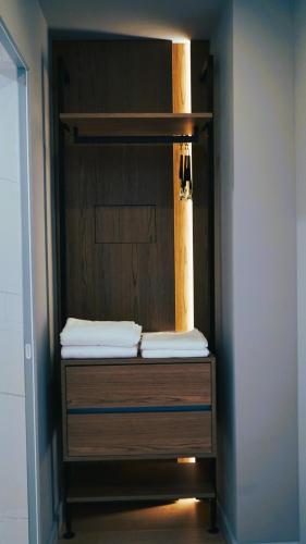 a closet with a wooden dresser with towels on it at Arbnor Boutique Hotel in Tirana