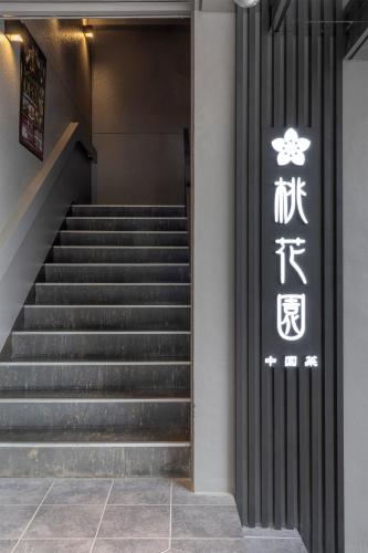 a staircase in a building with a sign on the wall at Cityroute Hotel in Osaka
