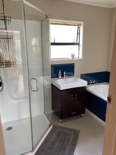 un baño con lavabo y ducha en A peaceful oasis, en Dunedin