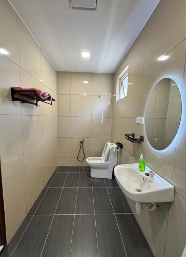 a bathroom with a toilet and a sink and a mirror at Heartstay Tanjong Karang 妍菁名宿 in Kampong Tanjong Karang